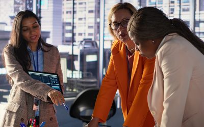 Multiethnic women executives uniting forces in a collaborative meeting, focused on data management and business development. Experts with leadership skills fighting for empowerment. Camera A.